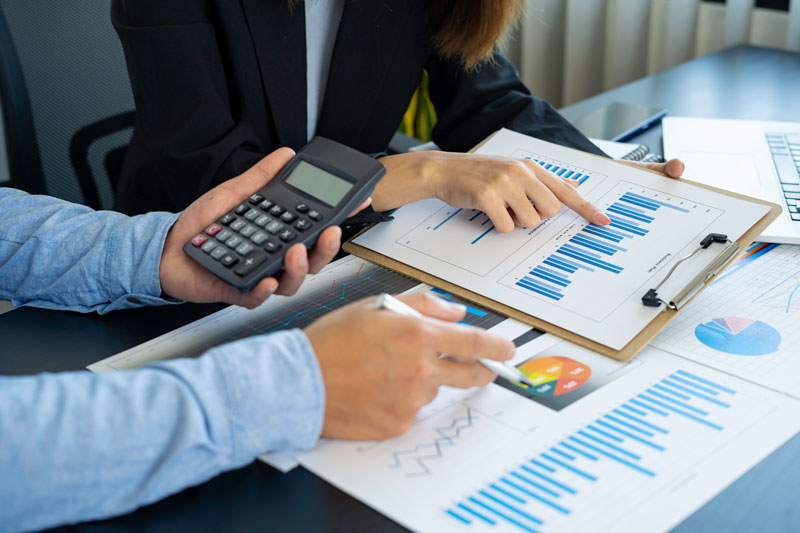 Två personer analyserar staplar och cirkeldiagram